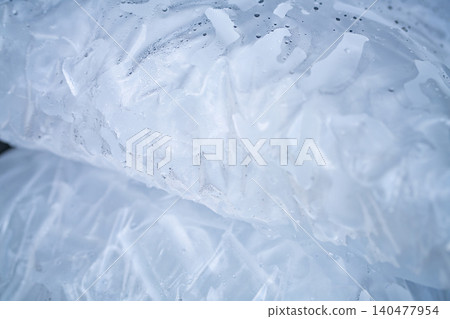 Closeup of tube ice inside a clear plastic bag. Convenient and lightweight packaging designed for easy transportation and storage. Hygiene and freshness for commercial and industrial applications. Closeup of tube ice inside a clear plastic bag. Convenient and lightweight packaging designed for easy transportation and storage. Hygiene and freshness for commercial and industrial applications. 140477954