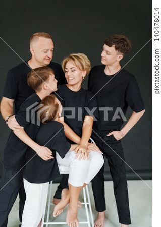 Family poses together in casual black shirts for a studio session 140478014