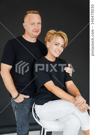 Couple poses for studio portrait in black and white attire Couple poses for studio portrait in black and white attire 140478030