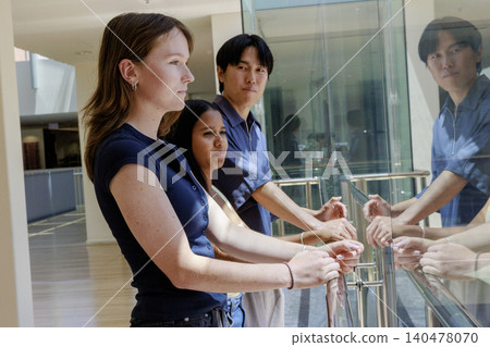 A group of university students looking out the classroom window at the sunny outside. A group of university students looking out the classroom window at the sunny outside. 140478070