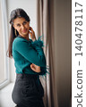 Portrait of a woman with long hair in a modern indoor setting 140478117