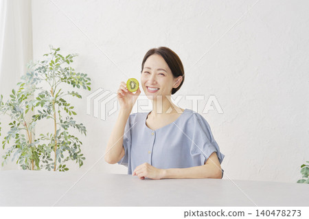 一位女士在客廳吃獼猴桃 140478273