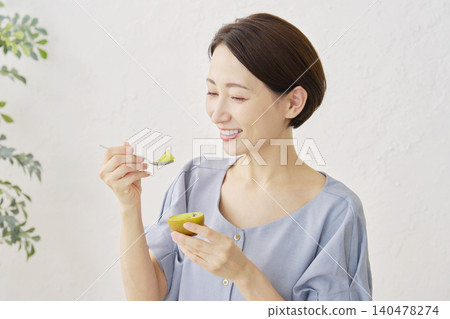 一位女士在客廳吃獼猴桃 140478274
