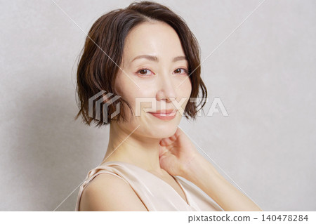 Middle-aged woman portrait gray background looking at camera Middle-aged woman portrait gray background looking at camera 140478284
