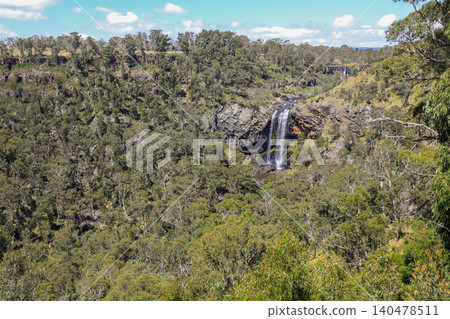 Scenic view of Ebor Falls and surrounding natural landscape in New South Wales, Australia. Waterfall cascading over rock formation within forest environment of Guy Fawkes River National Park. Scenic view of Ebor Falls and surrounding natural landscape in New South Wales, Australia. Waterfall cascading over rock formation within forest environment of Guy Fawkes River National Park. 140478511