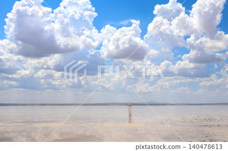 Young girl taking pictures on phone in salt lake Tuz Golu, Turkey.  Tourist takes photo using smartphone. Woman taking a picture of lake with her mobile phone.  Summer vacation, relaxing, travel, trip 140478613