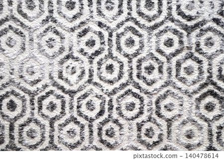 Texture of wool carpet with monochrome honeycomb pattern. Backdrop of wool rug with hexagon motif of gray, light grey and black colors 140478614