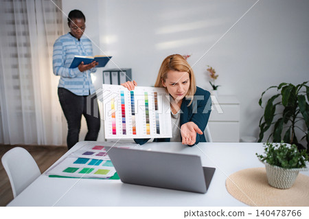 Woman expressing confusion during video call holding color palette Woman expressing confusion during video call holding color palette 140478766