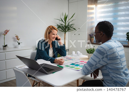 Businesswoman talking on phone during meeting with client 140478767