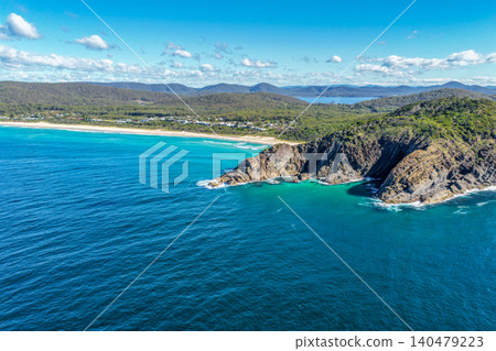 Aerial scene capturing the rocky headland of Charlotte Head and Boomerang Beach near Pacific Palms, NSW, Australia. Surrounded by clear turquoise waters, rugged coastal formations 140479223