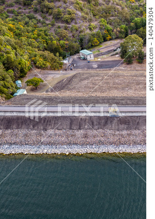 Vertical Aerial close up view of the Glenbawn Dam wall and surrounding landscape in NSW Australia. Drone photograph captures the engineering structure, reservoir waters and rugged mountain scenery Vertical Aerial close up view of the Glenbawn Dam wall and surrounding landscape in NSW Australia. Drone photograph captures the engineering structure, reservoir waters and rugged mountain scenery 140479304