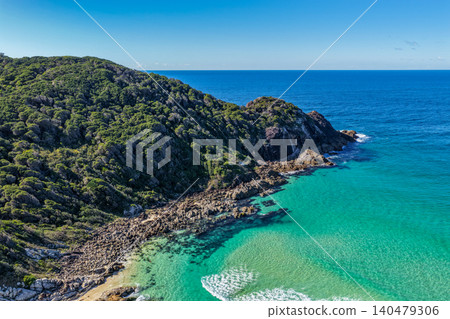 Aerial scene capturing Charlotte Head at Boomerang Beach near Pacific Palms, NSW, Australia. The rugged coastal headland, rocky shoreline and clear ocean waters showcase the striking natural beauty 140479306