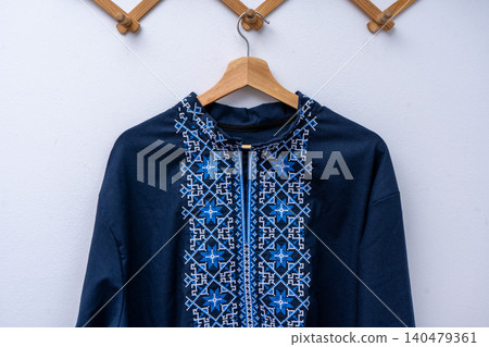 Ukrainian men embroidered shirt vyshyvanka. Blue ethnic linen clothing on wooden hanger Ukrainian men embroidered shirt vyshyvanka. Blue ethnic linen clothing on wooden hanger 140479361