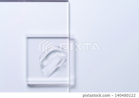 A sample of a transparent cosmetic skin care product on glass. Blue background 140480122