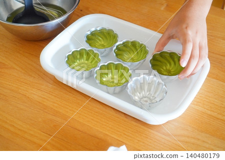 Photo of a child arranging molds for homemade jelly and a scene of the cooking process. Photo of a child arranging molds for homemade jelly and a scene of the cooking process. 140480179