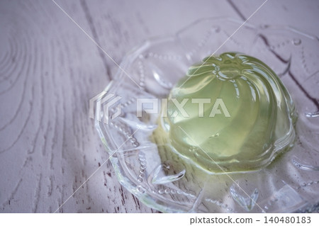 Photo of a translucent matcha jelly and a glass plate, a Japanese-style dessert. Photo of a translucent matcha jelly and a glass plate, a Japanese-style dessert. 140480183