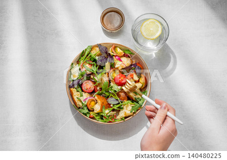 Tuscan panzanella salad with tomatoes, red onion, arugula, basil, cheese and bread in a bowl Tuscan panzanella salad with tomatoes, red onion, arugula, basil, cheese and bread in a bowl 140480225