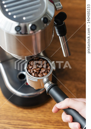 Preparing espresso with portafilter and home coffee machine in natural sunlight Preparing espresso with portafilter and home coffee machine in natural sunlight 140480233