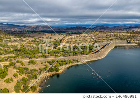 Vertical Aerial view of the Glenbawn Dam spillway and surrounding landscape in NSW Australia. Drone photograph captures the engineering infrastructure, expansive reservoir and rugged inland mountain Vertical Aerial view of the Glenbawn Dam spillway and surrounding landscape in NSW Australia. Drone photograph captures the engineering infrastructure, expansive reservoir and rugged inland mountain 140480981