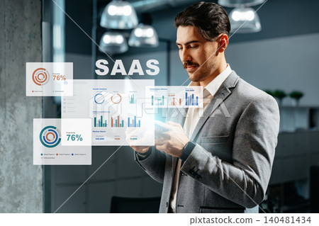 Business professional analyzes SaaS metrics on digital display in modern office setting Business professional analyzes SaaS metrics on digital display in modern office setting 140481434