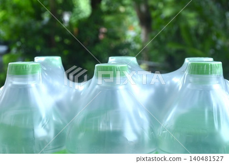 fresh drinking water plastic bottle with green cap in clear packaging on garden fresh drinking water plastic bottle with green cap in clear packaging on garden 140481527