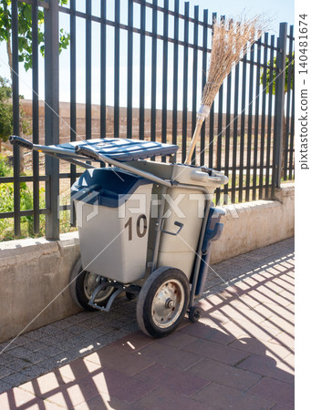 Street Cleaning Cart with Broom and Waste Bags Near Urban Park Street Cleaning Cart with Broom and Waste Bags Near Urban Park 140481674