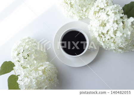 與安娜貝爾繡球花和咖啡杯一起享受寧靜的下午茶時光。 與安娜貝爾繡球花和咖啡杯一起享受寧靜的下午茶時光。 140482055