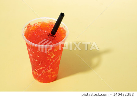 Red fruit slushie drink in plastic cup on yellow background. Copy space Red fruit slushie drink in plastic cup on yellow background. Copy space 140482398