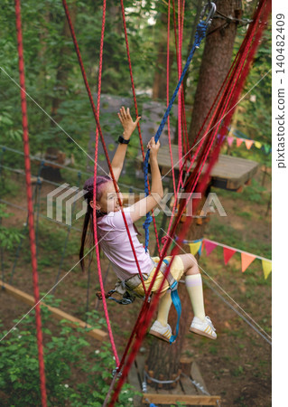 The child fell off the rope track, hanging on a safety rope. Active Sports Recreation Park The child fell off the rope track, hanging on a safety rope. Active Sports Recreation Park 140482409