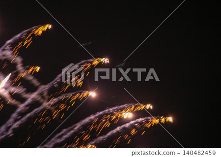 Stunning and colorful fireworks display in the night sky. Real fireworks background. Abstract of real shining fireworks against black background. Glowing fireworks show for celebration. Stunning and colorful fireworks display in the night sky. Real fireworks background. Abstract of real shining fireworks against black background. Glowing fireworks show for celebration. 140482459
