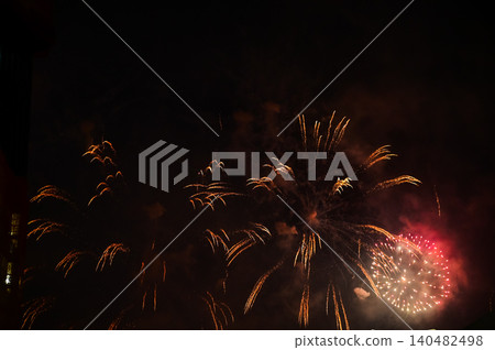 Stunning and colorful fireworks display in the night sky. Real fireworks background. Abstract of real shining fireworks against black background. Glowing fireworks show for celebration. Stunning and colorful fireworks display in the night sky. Real fireworks background. Abstract of real shining fireworks against black background. Glowing fireworks show for celebration. 140482498