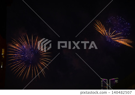 Stunning and colorful fireworks display in the night sky. Real fireworks background. Abstract of real shining fireworks against black background. Glowing fireworks show for celebration. Stunning and colorful fireworks display in the night sky. Real fireworks background. Abstract of real shining fireworks against black background. Glowing fireworks show for celebration. 140482507
