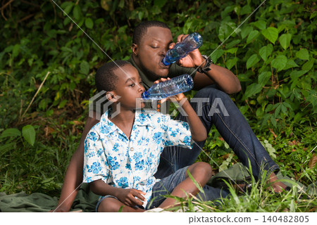 a family in the countryside with a bottle of water. a family in the countryside with a bottle of water. 140482805