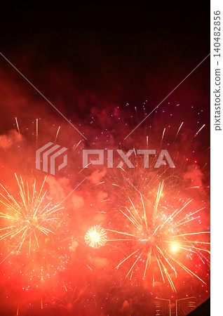 Stunning and colorful fireworks display in the night sky. Real fireworks background. Abstract of real shining fireworks against black background. Glowing fireworks show for celebration. 140482856