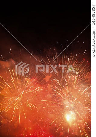 Stunning and colorful fireworks display in the night sky. Real fireworks background. Abstract of real shining fireworks against black background. Glowing fireworks show for celebration. 140482857