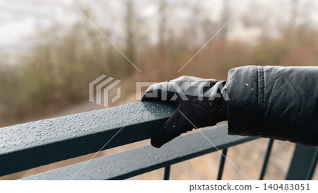 Hand Resting on Wet Metal Railing Hand Resting on Wet Metal Railing 140483051