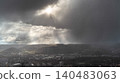 Sun Rays Through Storm Clouds Over City 140483063