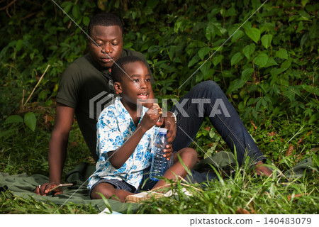 a family in the countryside with a bottle of water. a family in the countryside with a bottle of water. 140483079