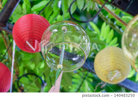 Transparent glass wind chimes and colorful lanterns create a cool summer atmosphere. Transparent glass wind chimes and colorful lanterns create a cool summer atmosphere. 140483250