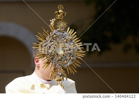 Priest holding monstrance during religious corpus christi procession Priest holding monstrance during religious corpus christi procession 140484122
