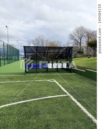 a soccer dugout situated on the sidelines of a sports field. Vertical image a soccer dugout situated on the sidelines of a sports field. Vertical image 140484159