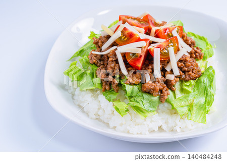 一張沖繩特色菜——塔可飯的照片,塔可飯裡有起司、生菜和番茄。 一張沖繩特色菜——塔可飯的照片,塔可飯裡有起司、生菜和番茄。 140484248