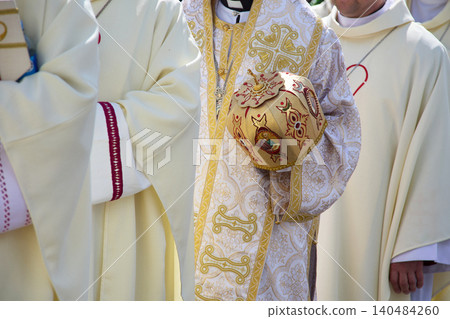 Orthodox clergy wearing vestment holding mitre during ceremony 140484260