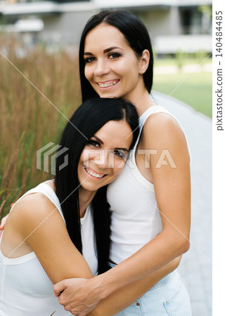 Happy Twin Sisters Hugging Close Up Portrait Happy Twin Sisters Hugging Close Up Portrait 140484485