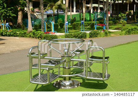 Rotating playground equipment or exercise equipment in a circular motion in a public park. Rotating playground equipment or exercise equipment in a circular motion in a public park. 140485117