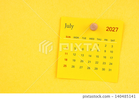 July 2027 calendar sheet with thumbtack on yellow color background. 140485141