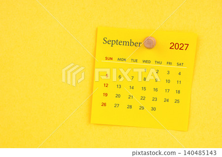 September 2027 calendar sheet with thumbtack on yellow color background. 140485143