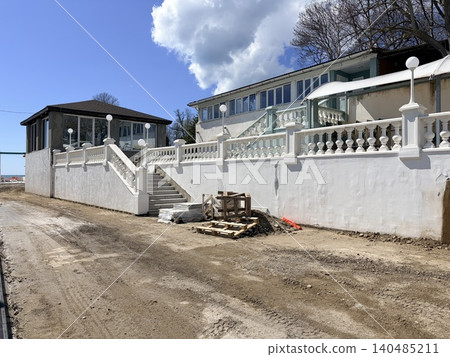A coastal property undergoing renovation or construction. . A pile of sand on the embankment construction site. Construction materials 140485211