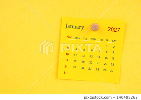January 2027 calendar sheet with thumbtack on yellow color background. 140485262