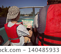 Father and son riding motor boat wearing safety vests having a ride in Neva river, Saint Petersburg 140485933